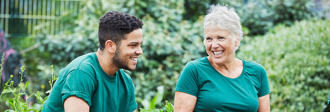 two people laughing together in a garden setting